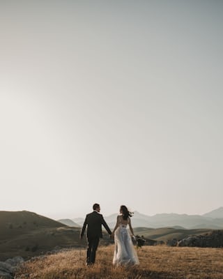 Newlyweds together above a sunlit hillside